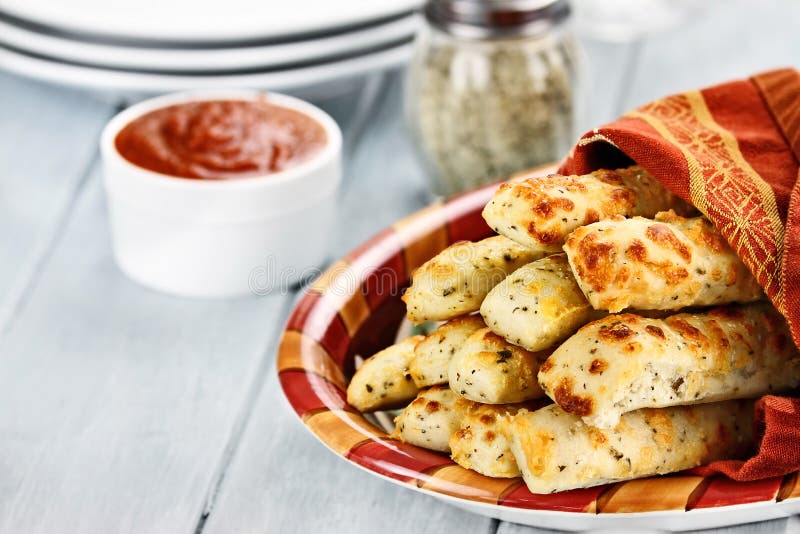 Ostliknande Asiago Breadsticks och Marinara sås royaltyfri bild Ostliknande Asiago Breadsticks och Marinara sås royaltyfri bild