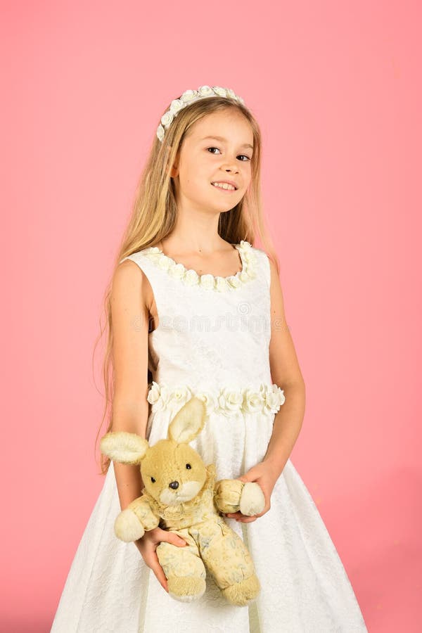 Oszałamiająco piękno młodej dziewczyny model w białych communion sukni stojakach w studiu z królik zabawką zdjęcia royalty free Oszałamiająco piękno młodej dziewczyny model w białych communion sukni stojakach w studiu z królik zabawką zdjęcia royalty free