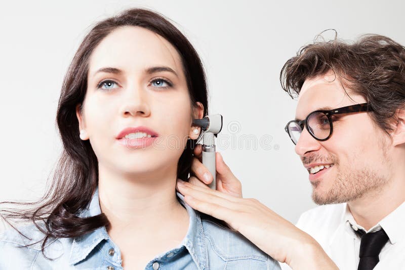 Ear Nose and Throat Examination. Otolaryngology Doctor Inspecting the ear canal and eardrum during an ENT exam royalty free stock photo Ear Nose and Throat Examination. Otolaryngology Doctor Inspecting the ear canal and eardrum during an ENT exam royalty free stock photo