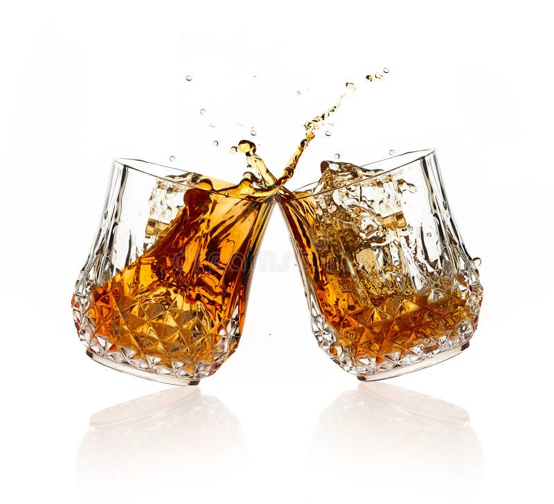 Cheers. A Toast with whiskey. Two glasses clicking together over white background. Splashing whisky on glasses of cut glass. Cheers. A Toast with whiskey. Two glasses clicking together over white background. Splashing whisky on glasses of cut glass