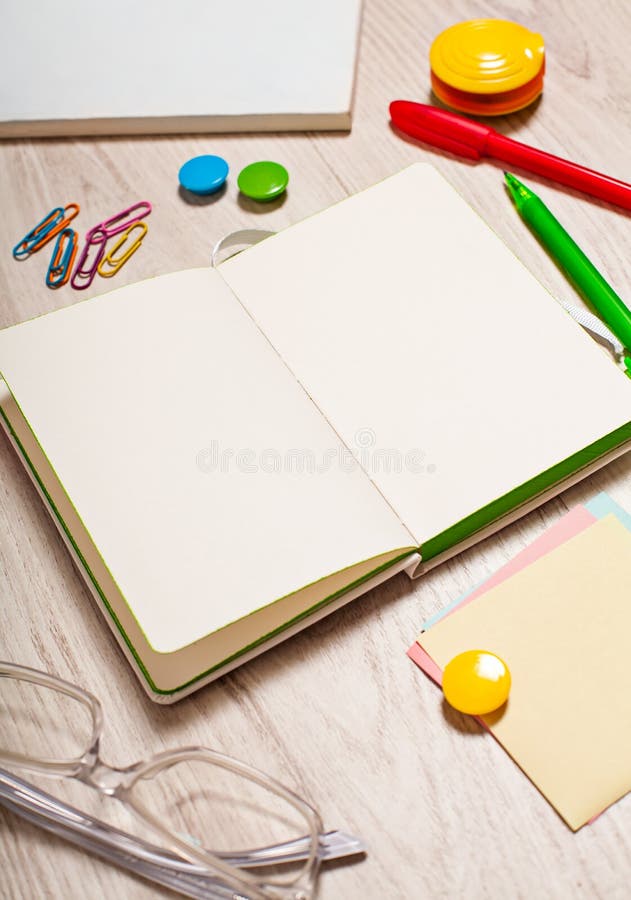 Otwarty notepad z pustymi stronami na stole z biurowymi narzędziami zdjęcie stock Otwarty notepad z pustymi stronami na stole z biurowymi narzędziami zdjęcie stock