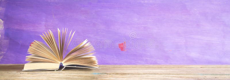 Otwiera książkę na purpurowym grungy tle, czytanie, edukacja, literatura, panorama