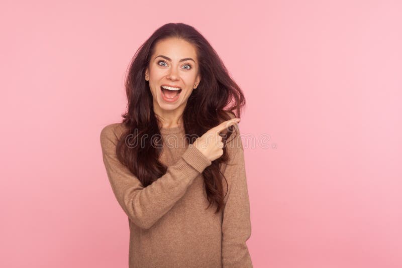Ouah attention à la publicité! Portrait de la jeune femme choquée surpris avec une chevelure brune pointée du côté images libres de droits