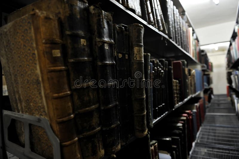 Detail with very old books on a shelf inside an archive room. Detail with very old books on a shelf inside an archive room