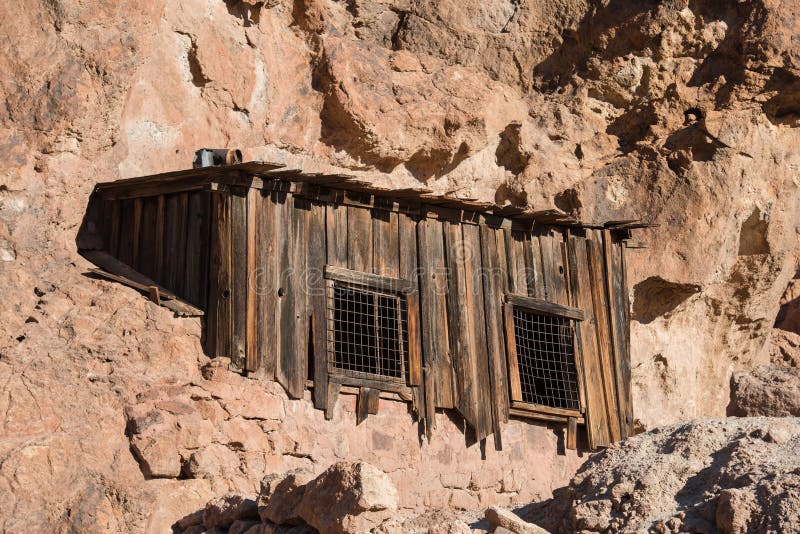 Oude, verlaten houten huis in rotsachtig woestijngebied in de bergen stock afbeelding