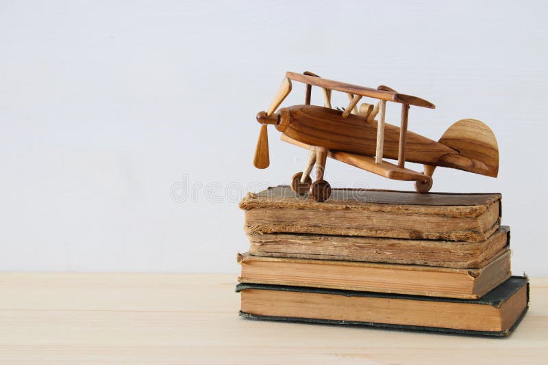 oude boeken naast vliegtuigstuk speelgoed op houten lijst royalty-vrije stock foto's oude boeken naast vliegtuigstuk speelgoed op houten lijst royalty-vrije stock foto's