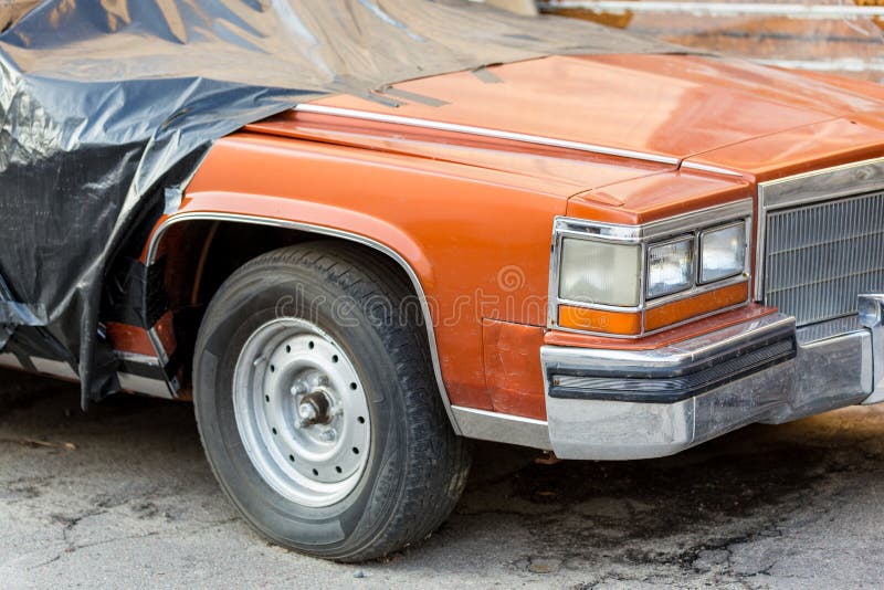 Oude gesloopte behandelde auto bij achtertuin van workshop Verlaten convertibel voertuig onder zwart gordijn dichtbij garagedeure stock afbeeldingen Oude gesloopte behandelde auto bij achtertuin van workshop Verlaten convertibel voertuig onder zwart gordijn dichtbij garagedeure stock afbeeldingen