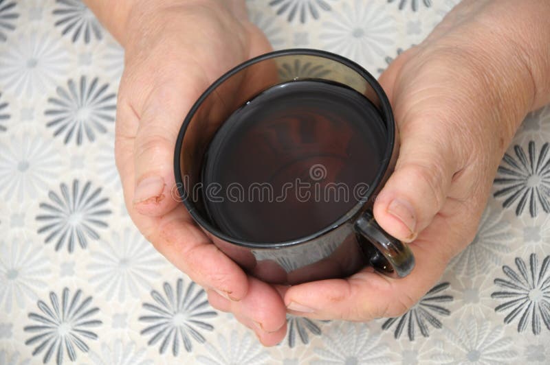 Oude Handenholding GLB van thee stock fotografie Oude Handenholding GLB van thee stock fotografie