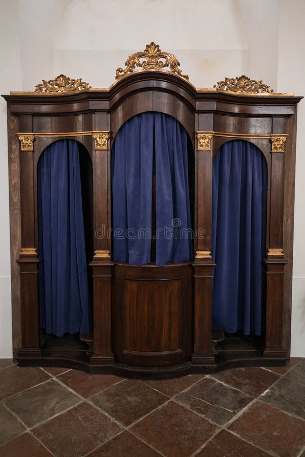 Oude houten biecht met gravures en zware blauwe gordijnen stock afbeeldingen Oude houten biecht met gravures en zware blauwe gordijnen stock afbeeldingen