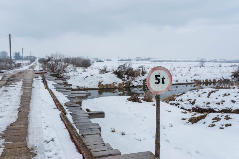 Oude houten brug over Olt-rivier bij wintertijd stock afbeeldingen