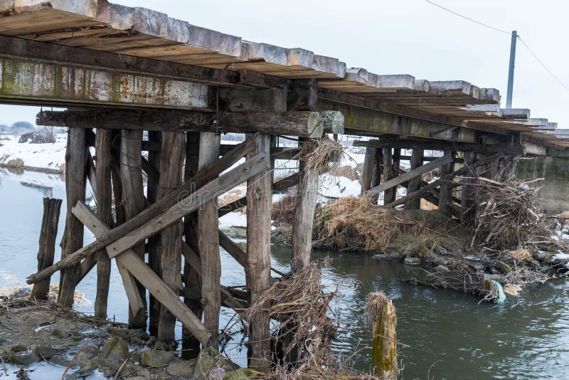 Oude houten brug over Olt-rivier bij wintertijd stock fotografie