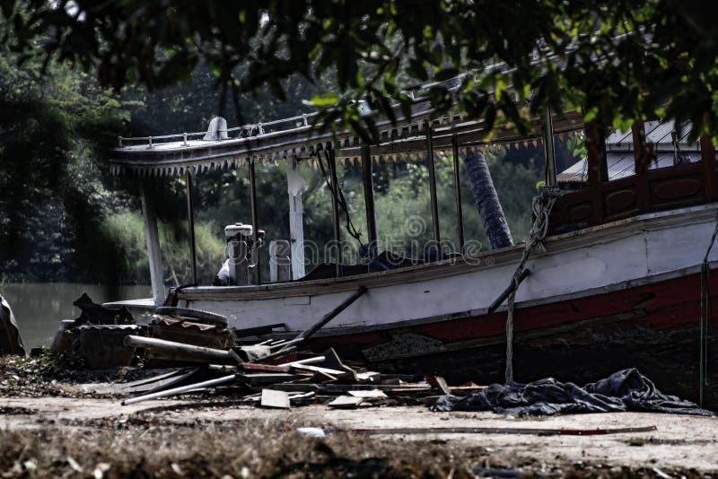 Oude houten die motorboot op het land aan de rivierkant wordt geparkeerd in Thailand, Uitstekend kleurenbeeld royalty-vrije stock foto's Oude houten die motorboot op het land aan de rivierkant wordt geparkeerd in Thailand, Uitstekend kleurenbeeld royalty-vrije stock foto's