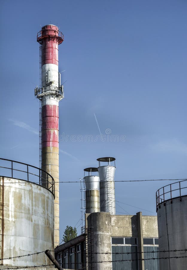 Oude industriële olie het verwarmen installatie met rode rook en blauwe duidelijke hemel royalty-vrije stock foto Oude industriële olie het verwarmen installatie met rode rook en blauwe duidelijke hemel royalty-vrije stock foto