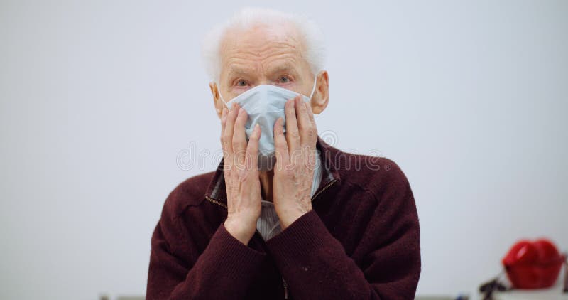 Oude man die een masker draagt tegen het coronavirus
