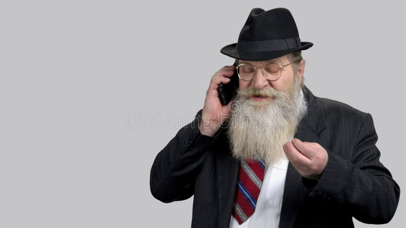 Oude man die telefonisch een zakelijke discussie voert.