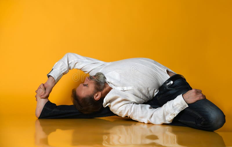 Oude mens het praktizeren yoga die uitrekkende oefeningen doen tegen oranje achtergrond stock foto Oude mens het praktizeren yoga die uitrekkende oefeningen doen tegen oranje achtergrond stock foto