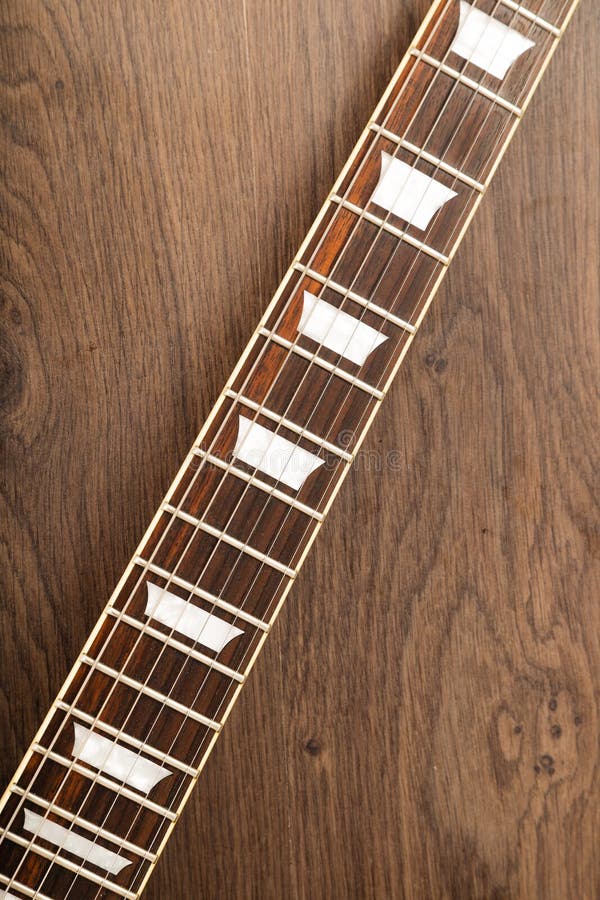 Oude mooie elektrische gitaar op een achtergrond van hout