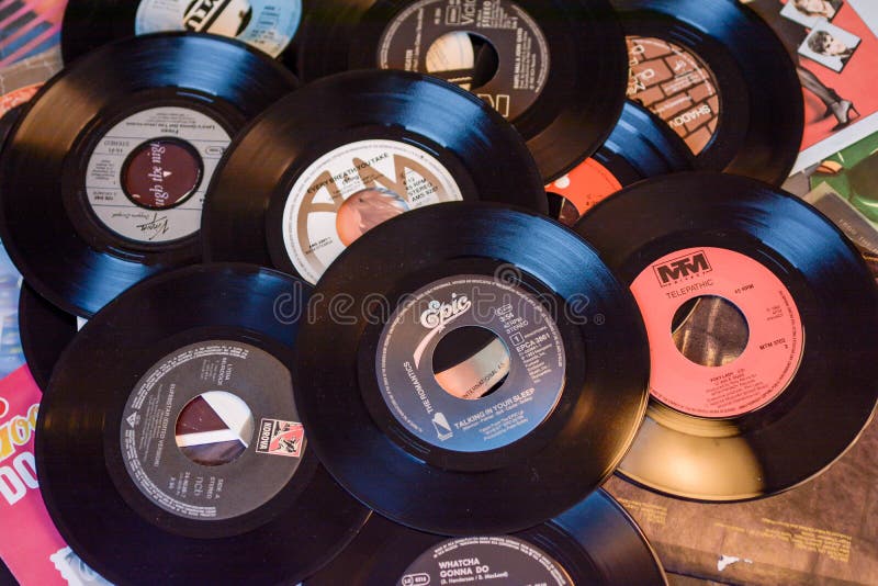 Old 45 rpm single records, backgrounds with modern touch, mobile phone and camera. We shoot 45 rpm oldies single with modern touch in macro photography. With camera on famous artists, cases and without case, lighted with umbrella soft tone light. Natural colors. Old 45 rpm single records, backgrounds with modern touch, mobile phone and camera. We shoot 45 rpm oldies single with modern touch in macro photography. With camera on famous artists, cases and without case, lighted with umbrella soft tone light. Natural colors.