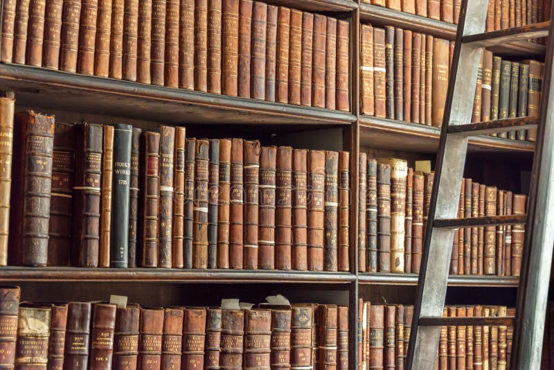 Oude uitstekende boeken op houten boekenrek en ladder in een bibliotheek stock afbeeldingen Oude uitstekende boeken op houten boekenrek en ladder in een bibliotheek stock afbeeldingen