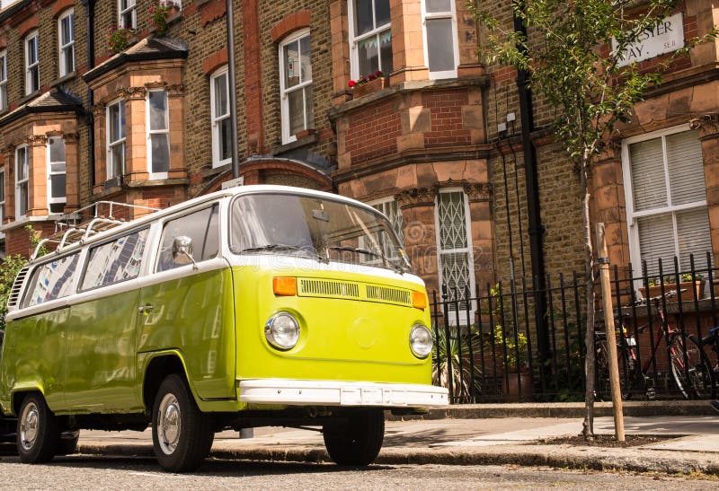 Oude uitstekende groene die bestelwagen in een straat met victorian huizen wordt geparkeerd stock fotografie Oude uitstekende groene die bestelwagen in een straat met victorian huizen wordt geparkeerd stock fotografie