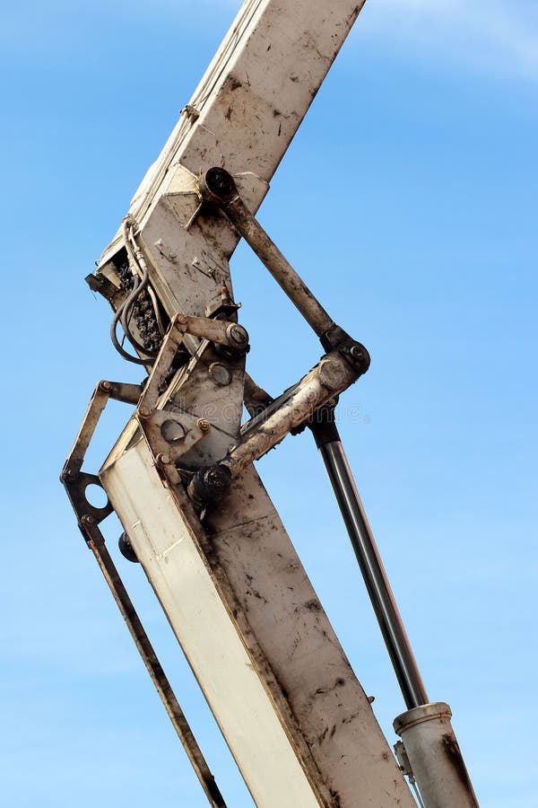 Oude vettige en vuile hydraulische zuiger van witte backhoe tegen blauwe hemel Zware machine voor uitgraving in bouwwerf royalty-vrije stock afbeeldingen Oude vettige en vuile hydraulische zuiger van witte backhoe tegen blauwe hemel Zware machine voor uitgraving in bouwwerf royalty-vrije stock afbeeldingen