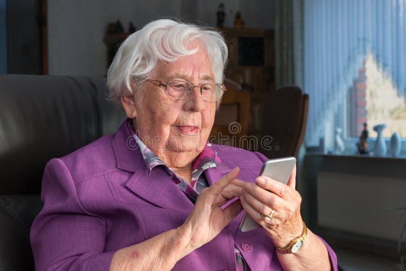 Oude vrouw die een smartphone gebruiken stock foto Oude vrouw die een smartphone gebruiken stock foto
