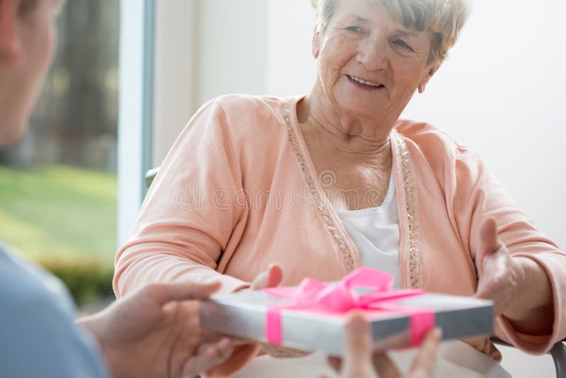 Oude vrouw die heden geven stock afbeeldingen Oude vrouw die heden geven stock afbeeldingen