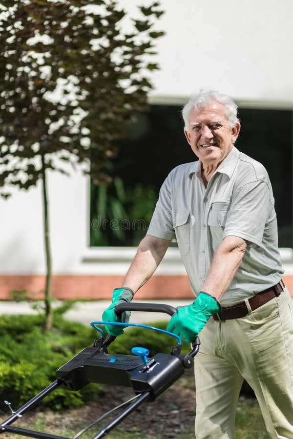 Oudere tuinman met grasmaaimachine royalty-vrije stock afbeelding Oudere tuinman met grasmaaimachine royalty-vrije stock afbeelding