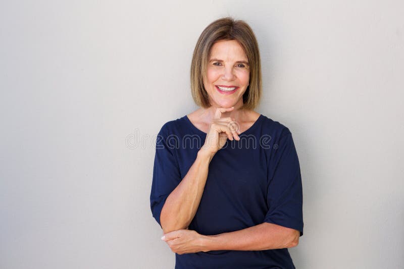 Oudere vrouw die met hand aan kin glimlachen royalty-vrije stock foto's Oudere vrouw die met hand aan kin glimlachen royalty-vrije stock foto's