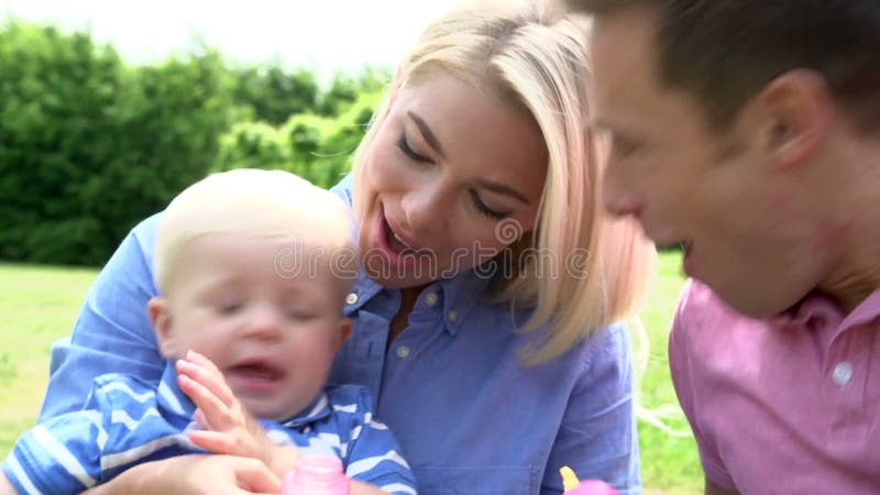 Ouders die Bellen voor Jonge Jongen in Tuin blazen