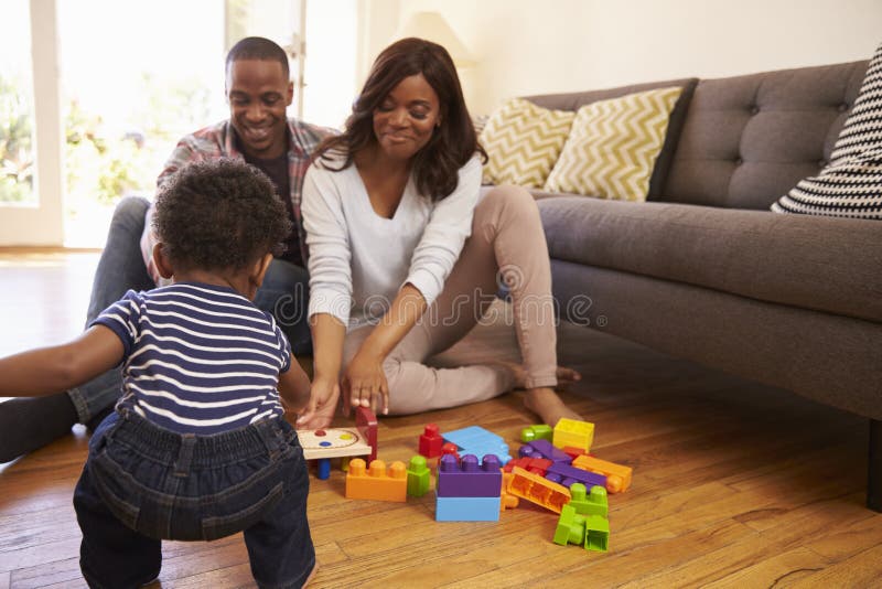 Ouders en Zoons het Spelen met Speelgoed op Vloer thuis royalty-vrije stock afbeeldingen Ouders en Zoons het Spelen met Speelgoed op Vloer thuis royalty-vrije stock afbeeldingen