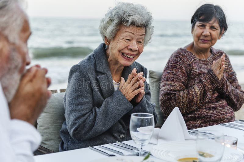 Oudsten die een dinerpartij hebben bij het strand stock afbeelding Oudsten die een dinerpartij hebben bij het strand stock afbeelding