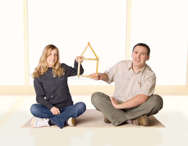 Our Home. Yong girl and man holding a house made of ruler Our Home. Yong girl and man holding a house made of ruler