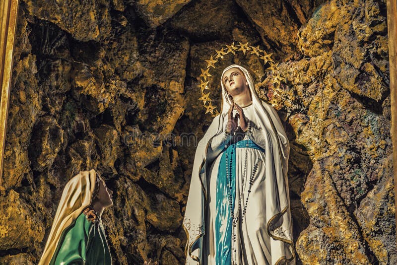 The apparition of the Blessed Virgin Mary surrounded by stars in the grotto of Lourdes. The apparition of the Blessed Virgin Mary surrounded by stars in the grotto of Lourdes