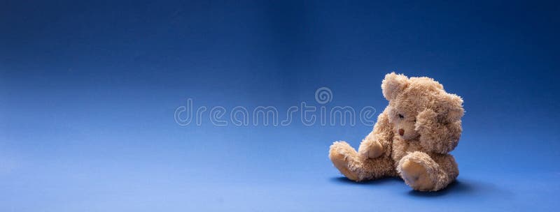 Ours de nounours triste, tenant sa tête, se reposant à l'arrière-plan vide bleu de pièce, bannière photo stock Ours de nounours triste, tenant sa tête, se reposant à l'arrière-plan vide bleu de pièce, bannière photo stock