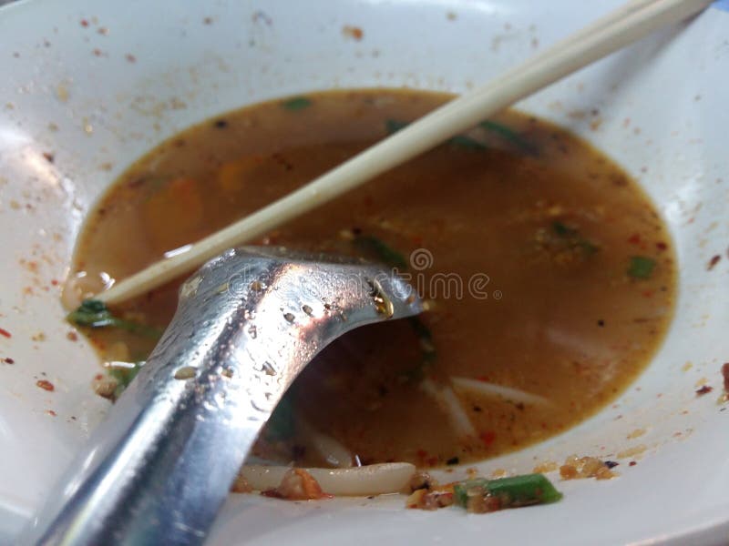 Out of Noodle with Chopsticks and a Spoon in a Cup of Water Stock Photo