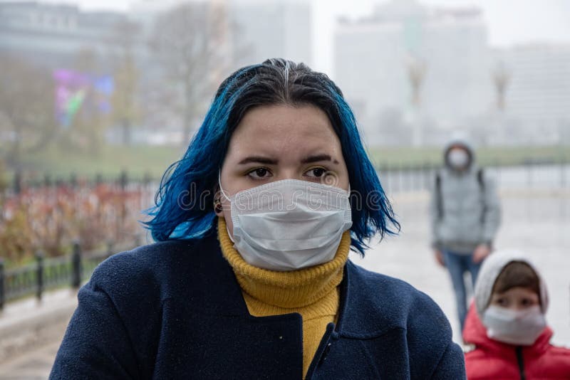 An outbreak of diseases in the city. Risk of infection with the virus on the street. Passers - by in medical masks are walking