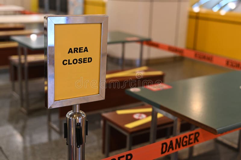 Outdoor cafe placed a yellow closed sign for a pandemic lockdown period