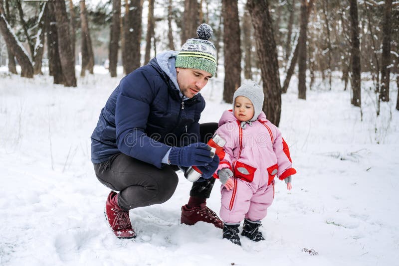 Outdoor family activities for happy winter holidays. Happy father and mother playing with little baby toddler girl