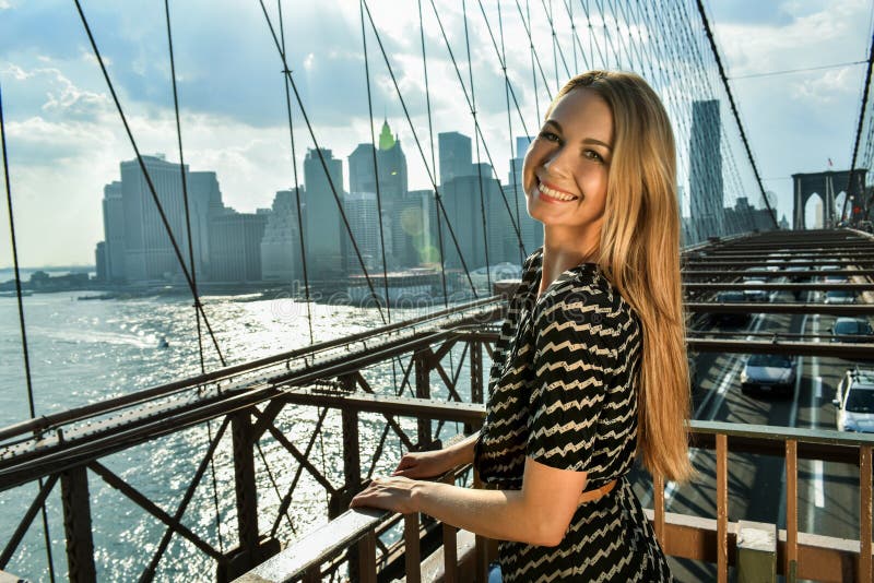 Outdoor fashion portrait of beautiful smiling young woman posing on the Brooklyn Bridge. stock photo Outdoor fashion portrait of beautiful smiling young woman posing on the Brooklyn Bridge. stock photo