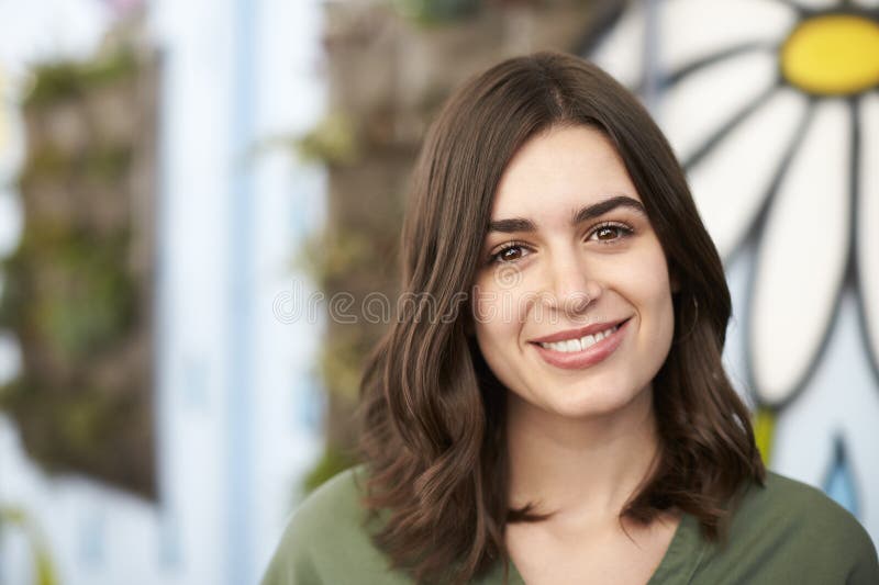 Outdoor Head And Shoulders Portrait Of Smiling Young Woman Stock Photo