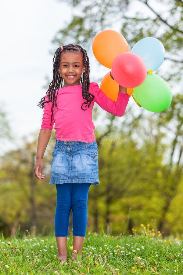 Outdoor portait of a cute young little black girl playing with royalty free stock photos Outdoor portait of a cute young little black girl playing with royalty free stock photos
