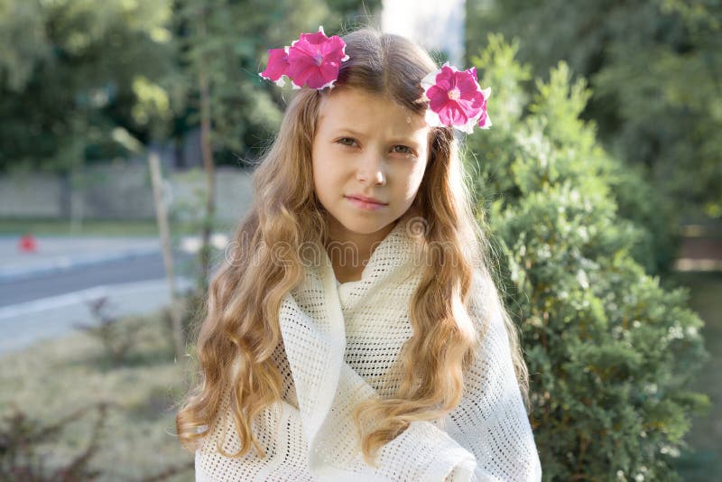 Outdoor portrait of beautiful girl child blonde with wreath of fresh pink flowers