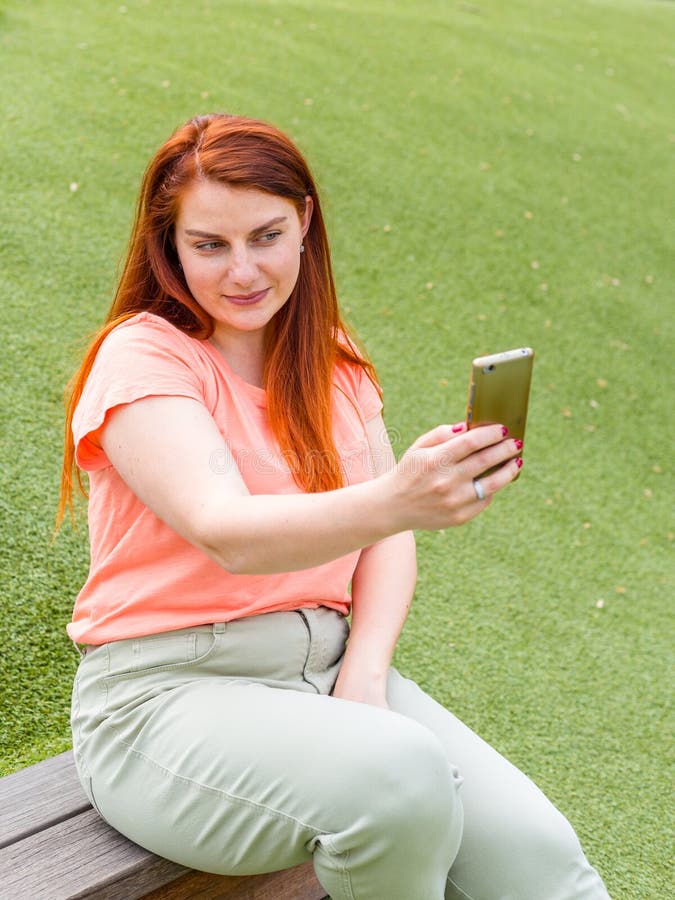 Outdoor Portrait Of Beautiful Ginger Girl Taking A Selfie Happy Young Woman Using Smart Phone 