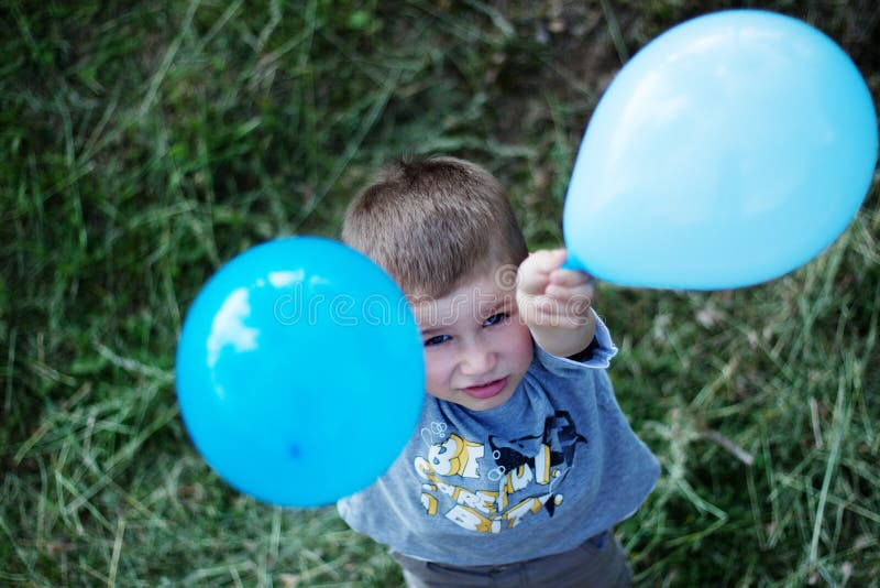 Outdoor portrait of cute boy with balloons