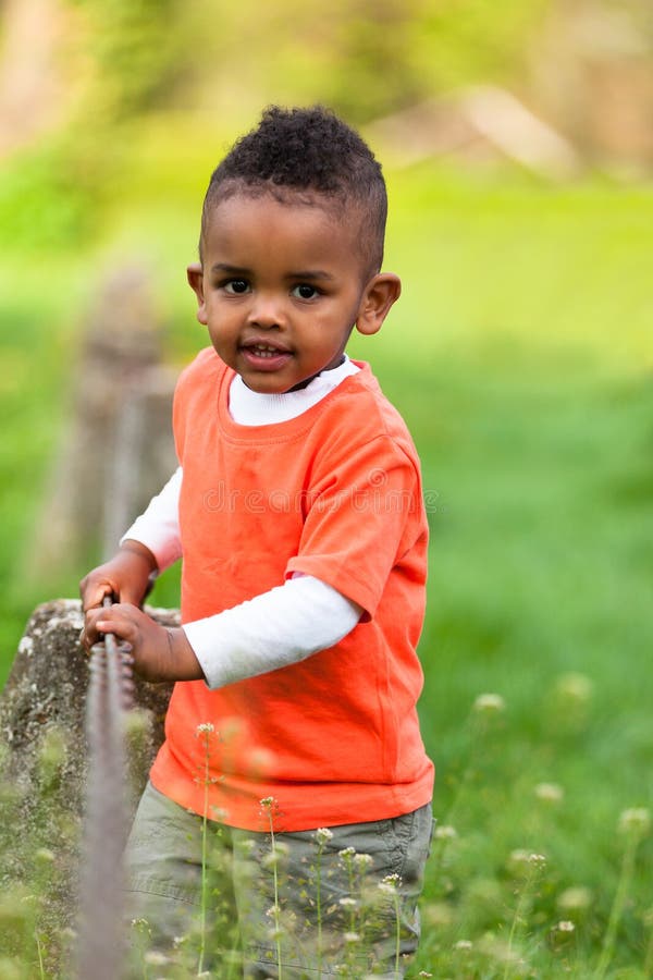 Outdoor portrait of a cute young little black boy playing outsi