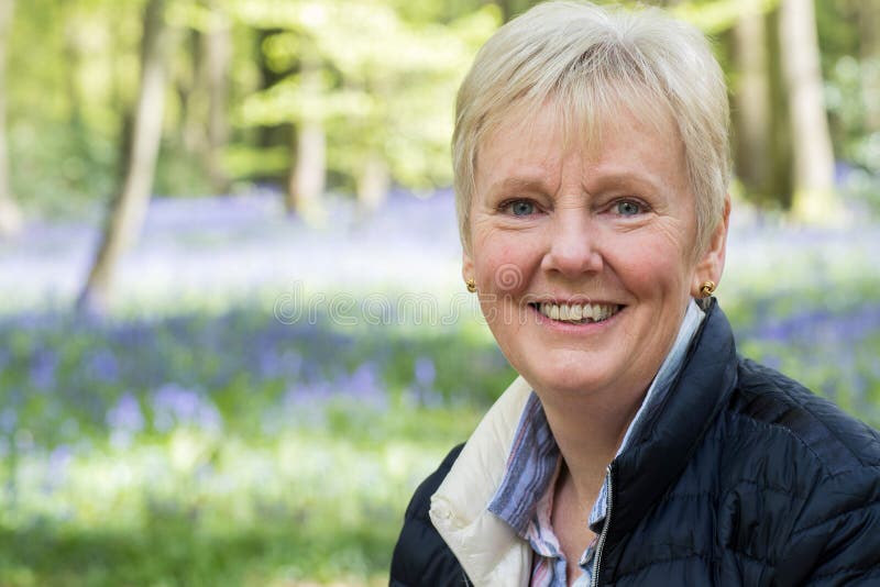 Outdoor Portrait Of Happy Senior Woman In Bluebell Wood royalty free stock photo Outdoor Portrait Of Happy Senior Woman In Bluebell Wood royalty free stock photo