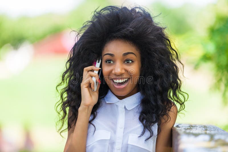 Outdoor portrait of a teenage black girl using a mobile phone -