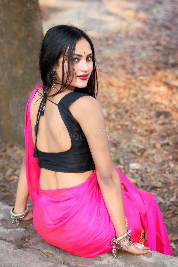 outdoor portrait very beautiful straight haired attractive woman wearing pink saree light jewellery sitting concrete 244859089