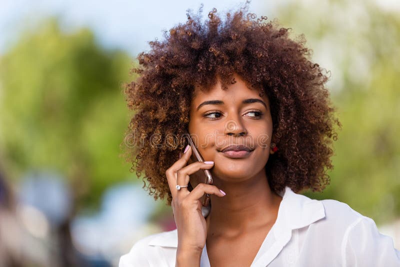 Outdoor portrait of a Young black African American young woman speaking on mobile phone